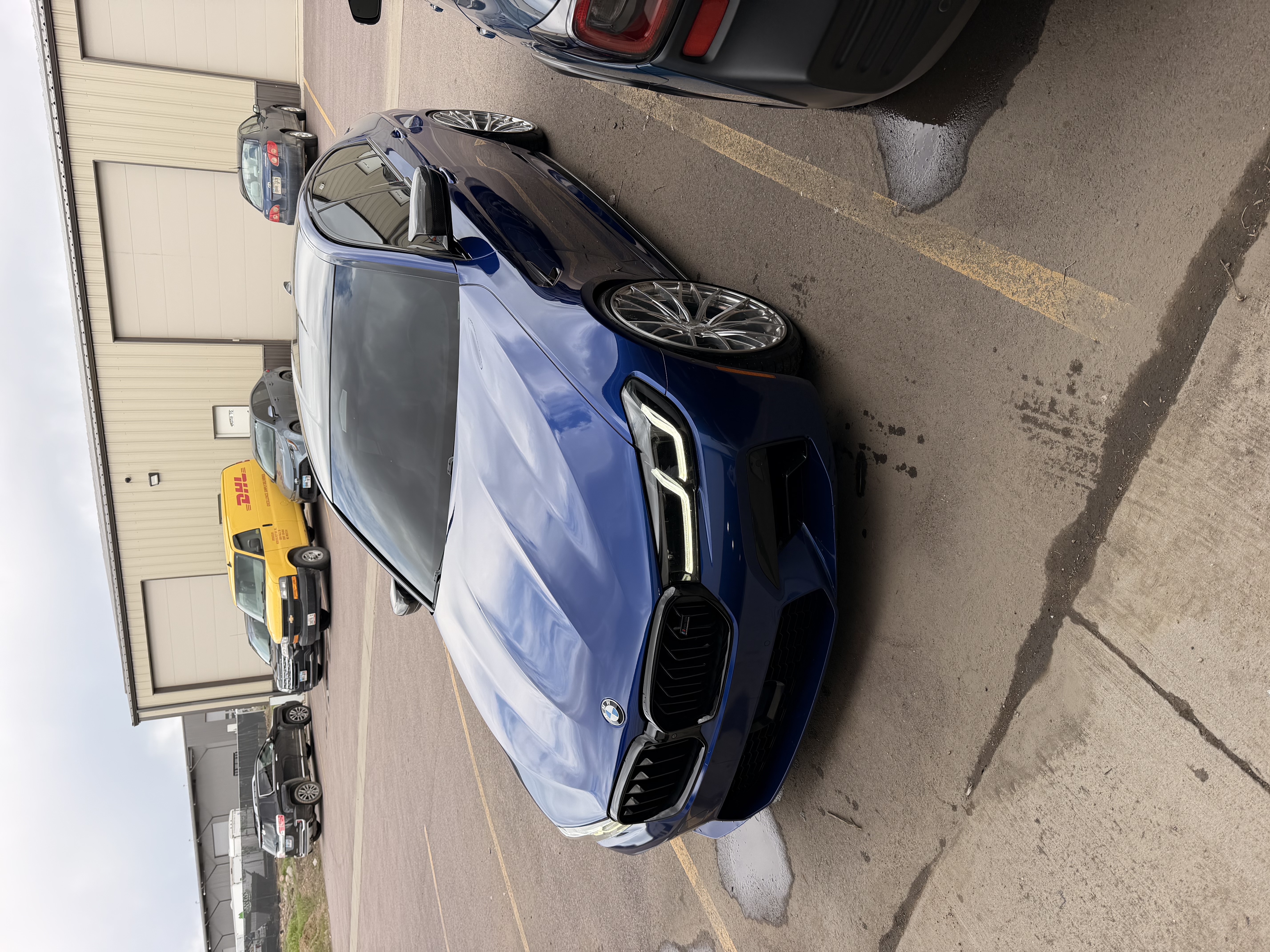 Metallic blue BMW M5 sedan with glossy, reflective paint after detailing at JTS